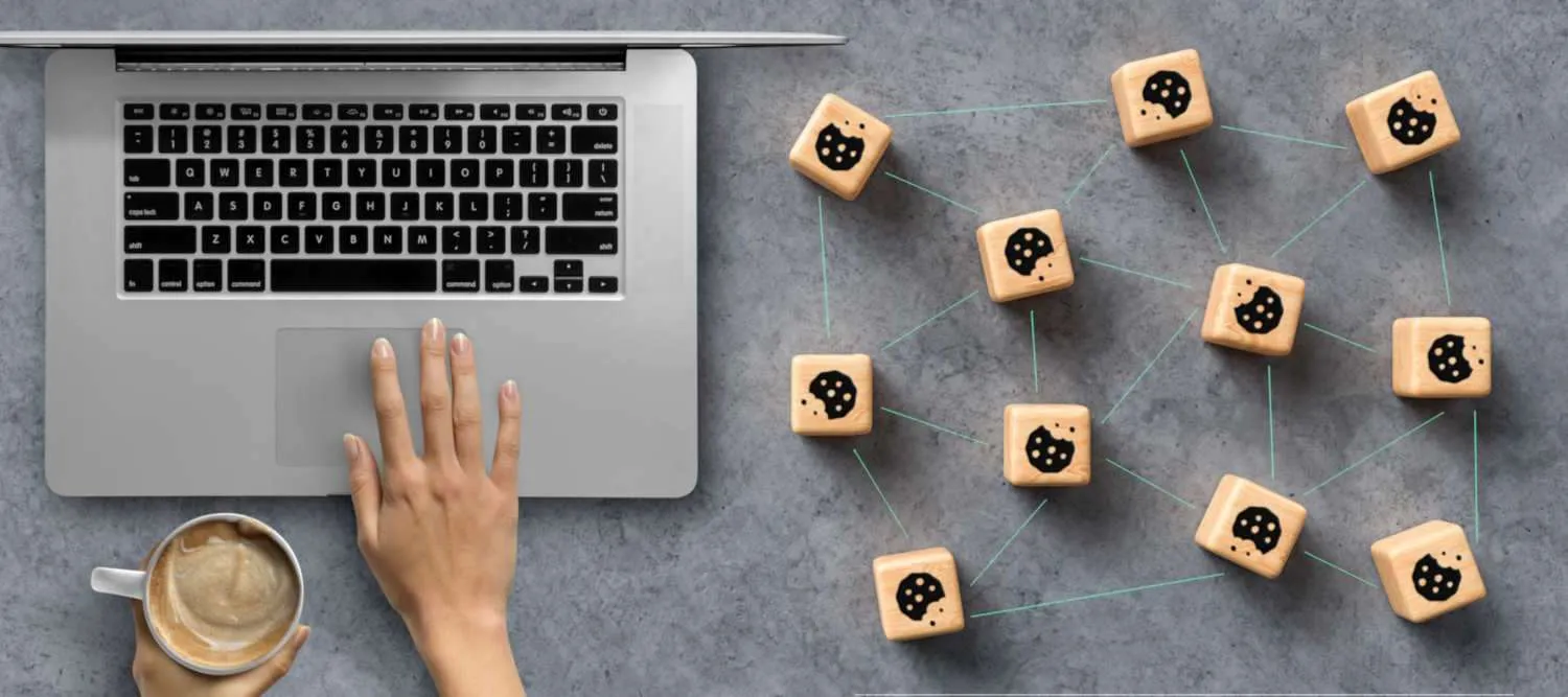 Cookies die aan elkaar gelinkt zijn, naast een laptop.